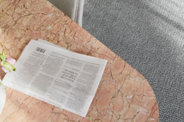 Image depicting quality Bremworth carpet and a coffee table with various items on it, including a newspaper